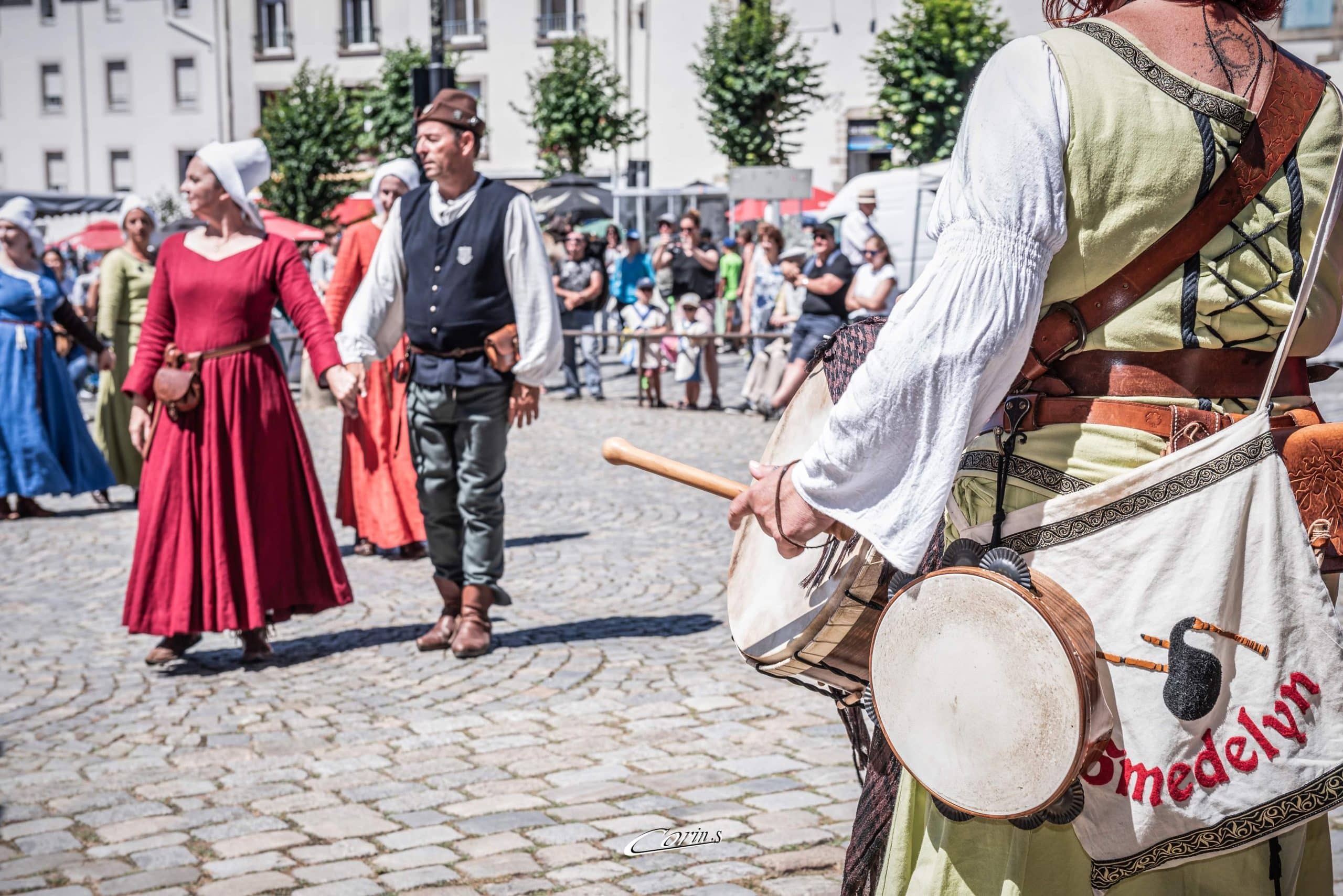 Prestation médiévale avec danseurs et musiciens en action.